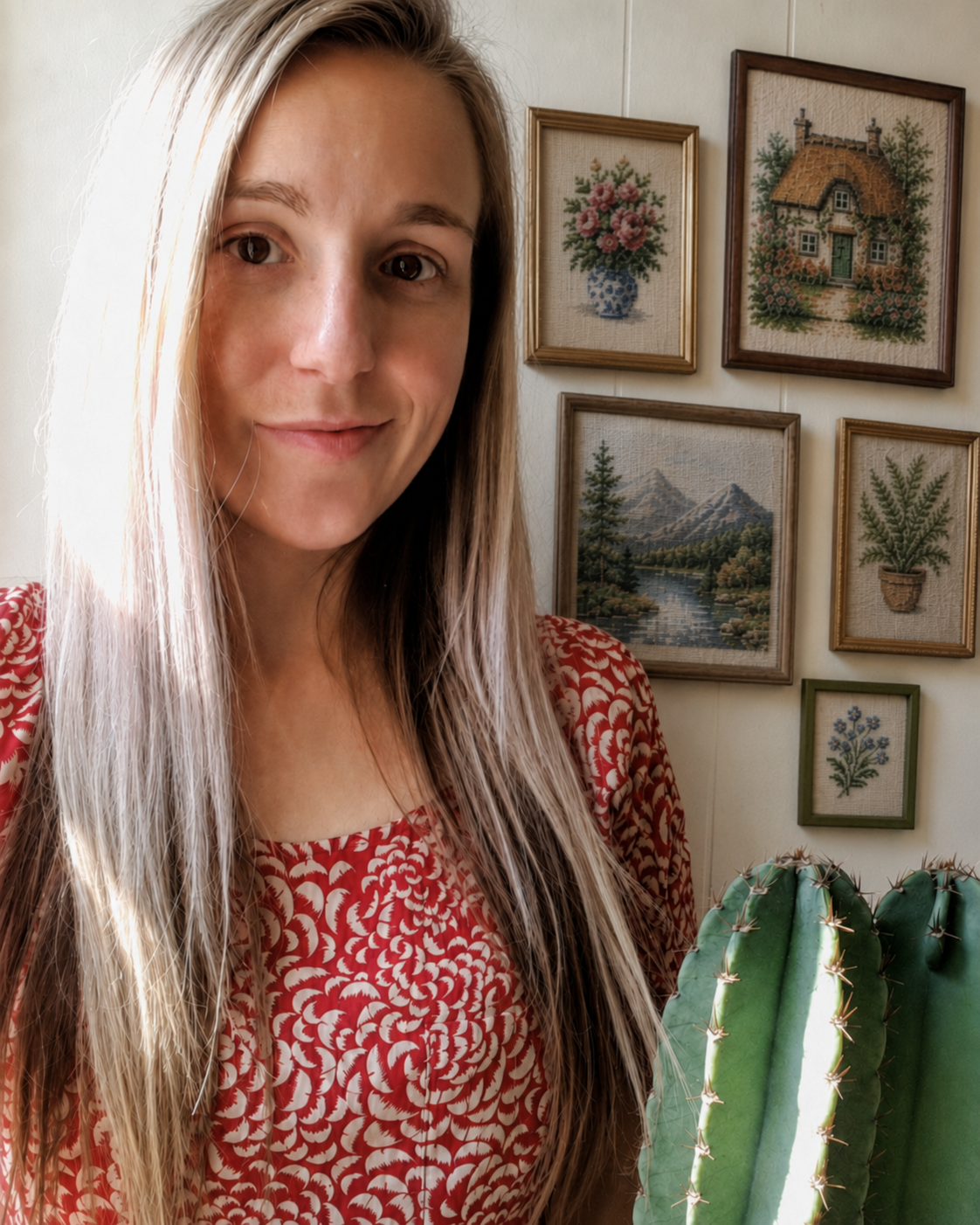 Meg Patrick, founder of Stitch Hiker Company, surrounded by framed cross-stitch artwork
